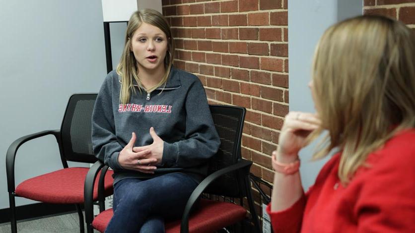 Student talks with invited speaker during group gathering